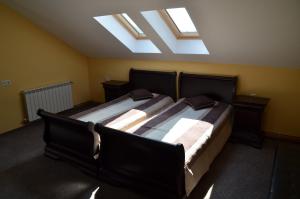 a bedroom with two beds and a skylight at Pensiunea Koruna in Poenari