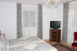 een slaapkamer met een bed en een televisie en gordijnen bij Gasthaus zum Adler in Baden-Baden