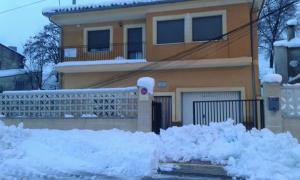 una pila de nieve delante de una casa en Apartamentos Rurales Carlos, en Barracas