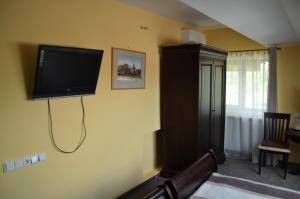a living room with a flat screen tv on the wall at Pensiunea Koruna in Poenari