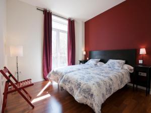 1 dormitorio con cama y pared roja en Apartamentos Murallas de Sevilla, en Sevilla
