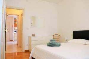 a bedroom with a white bed with a green bag on it at Sweet Home San Lazzaro in San Lazzaro di Savena