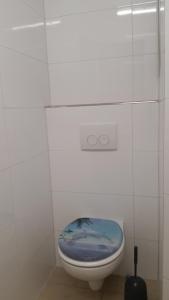 a bathroom with a toilet with a blue lid at Gasthaus zum Adler in Baden-Baden +19 photos