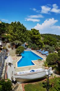 a boat is sitting next to a swimming pool at Villa Madag in Koukounaries