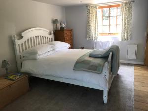 a bedroom with a white bed and a window at Stapehill Lodge B&B in Hampreston