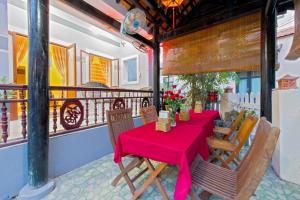 a table with a red table cloth on a balcony at Bougain Villeas Homestay in Hoi An