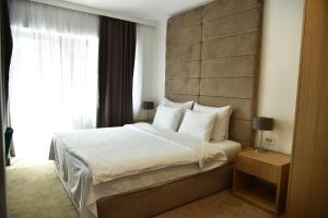 Un dormitorio con una cama grande y una ventana en Miznah Hotels & Resorts en Bačka Topola