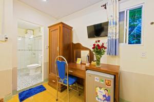 a home office with a desk and a blue chair at Bougain Villeas Homestay in Hoi An