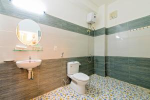 a bathroom with a toilet and a sink and a mirror at Bougain Villeas Homestay in Hoi An +25 photos