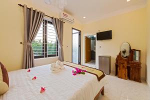 a bedroom with a bed with flowers on it at Bougain Villeas Homestay in Hoi An