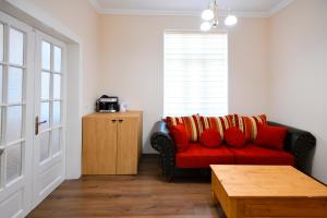 a living room with a red couch with red pillows at Shipka 1 in Varna City