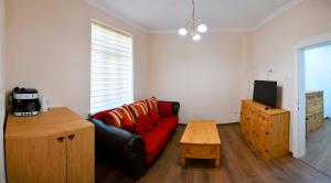 a living room with a red couch and a table at Shipka 1 in Varna City