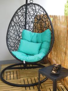 une chaise suspendue avec un coussin bleu sur une terrasse dans l'établissement "CHEZ AURELIE" T5 100m2 4ch 2sdb parking terrasse TALENCE, à Talence