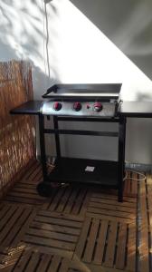 a barbecue grill sitting on top of a wooden floor at "CHEZ AURELIE" T5 100m2 4ch 2sdb parking terrasse TALENCE in Talence