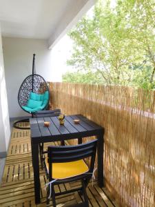 塔朗斯的住宿－"CHEZ AURELIE" T5 100m2 4ch 2sdb parking terrasse TALENCE，一个带桌椅和围栏的庭院