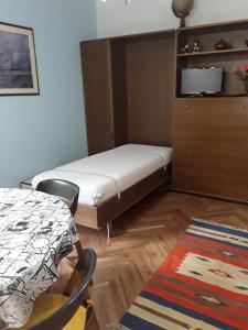 アオスタにあるAppartamento Fantasia CIR Aosta 0241の小さなベッドルーム(ベッド1台、テーブル付)