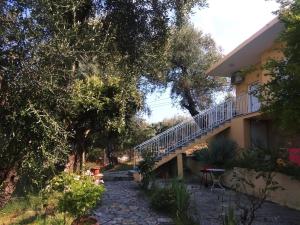 a house with a staircase next to a yard at Barbara's Sea View Home in Benitses