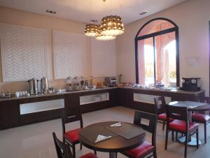 a kitchen with a table, chairs and a refrigerator at Hotel Relax Marrakech in Marrakesh