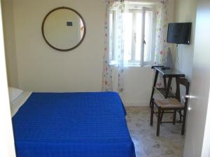 una camera da letto con un letto blu e uno specchio di Affittacamere il girasole a Recanati