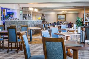 a restaurant with tables and chairs and a bar at Kinloch Hotel, Isle of Arran in Blackwaterfoot