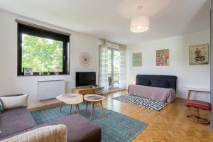 ein Wohnzimmer mit einem Sofa und einem TV in der Unterkunft Appartement Lyon Centre Confluence 100 m2 Parking Terrasses in Lyon