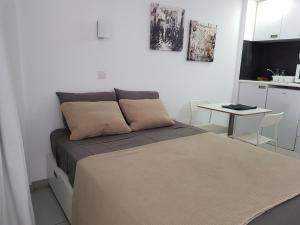 a small bedroom with a bed and a table at Yialos Luxury Apartments in Perivolia