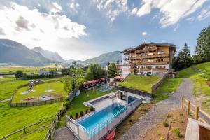 an estate in the mountains with a swimming pool at Hotel Babymio in Kirchdorf in Tirol