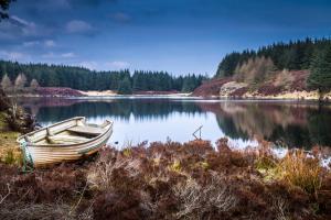 a boat sitting on the shore of a lake at Kinloch Hotel, Isle of Arran in Blackwaterfoot