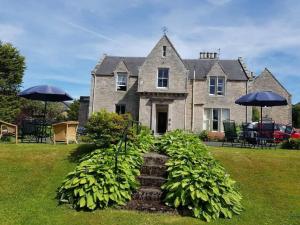 une maison avec une bande de plantes devant elle dans l'établissement Allerton House, à Jedburgh