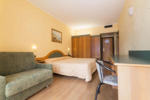 a bedroom with a bed and a couch and a table at Hotel Lido in Gargnano +51 photos