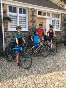 un grupo de personas con sus bicicletas delante de una casa en teapot cottage en Great Torrington