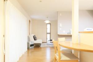 a living room with a table and a kitchen at Tokaichi inn 一軒家貸切 in Hiroshima