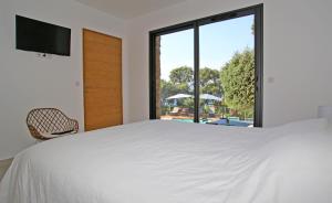 ポルティシオにあるVilla Vue Mer, piscine chauffée, tennisのベッドルーム(大きな白いベッド1台、窓付)