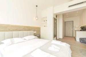 ein Schlafzimmer mit einem großen weißen Bett und zwei weißen Handtüchern in der Unterkunft Hermes studio in Thessaloniki