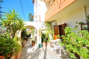 un patio de una casa con plantas y una mesa en Anthoula Sunrise, en Kokkíni Khánion