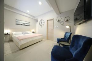 a bedroom with a bed and two chairs and a clock at Teatro Verdi Accommodation in Zadar