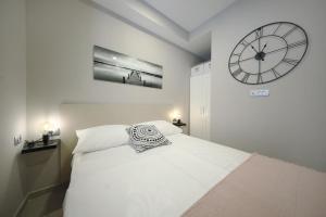 a bedroom with a bed with a clock on the wall at Teatro Verdi Accommodation in Zadar