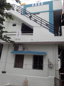 a white building with a staircase and a window at Rks Homestay in Hampi