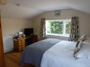 a bedroom with a white bed and a window at Manor Farm Stay in Sutton on Sea
