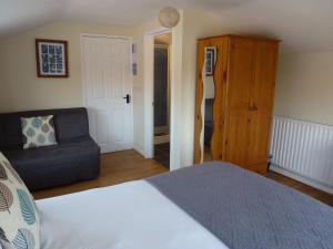 1 dormitorio con 1 cama y 1 sofá en Manor Farm Stay en Sutton on Sea