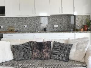 a white couch with pillows in a kitchen at Tavira Apartment in Tavira