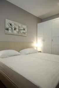 a white bed with two pillows in a bedroom at Teatro Verdi Accommodation in Zadar