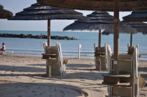 un gruppo di sedie e ombrelloni in spiaggia di Villa L'Aurora a Pescara