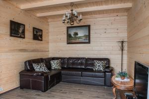 a living room with a leather couch and a table at Domik u morya in Gribovka