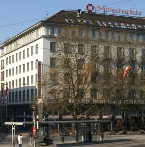 um grande edifício numa rua com pessoas em frente em Grand Hotel Mussmann em Hanôver