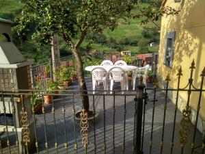 un grupo de sillas blancas y un árbol en el balcón en Ca Mi Güela en Aller