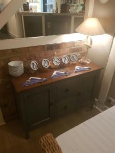 a room with a table with a lamp and plates at The Boathouse in Sutton Bridge