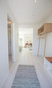 a living room with white walls and a rug at Kunstart20 in Saltum