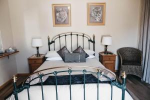 1 dormitorio con 1 cama, 1 silla y 2 lámparas en Karoo Ouberg Guest Lodge en Middelburg