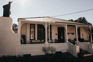 Casa blanca con porche delantero y puerta en Karoo Ouberg Guest Lodge en Middelburg